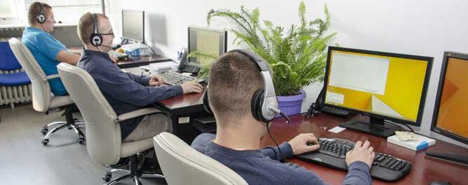 dečak sa slušalicama ispred lap topa