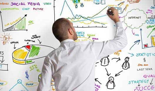 čovek crta grafikone i statistike po beloj tabli